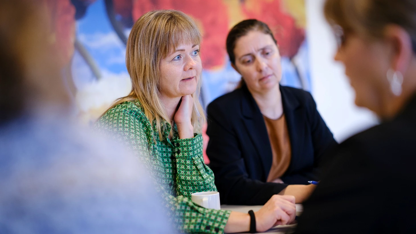 En gruppe sygeplejersker sidder til møde