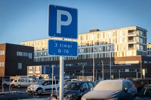 Parkeringsskilt viser 3 timers parkering fra kl. 8-16 foran Regionshospitalet Gødstrup, der ses i baggrund.
