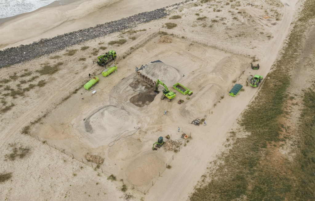 Dronefoto fra den 12. juni, da der blev gravet ned til giftdepotet. Dagen efter blev 130 tons forurenet jord/sand flyttet væk fra høfden og leveret i containere til to miljøfirmaer, er arbejder med nye rensemetoder. Foto: Region Midtjylland 