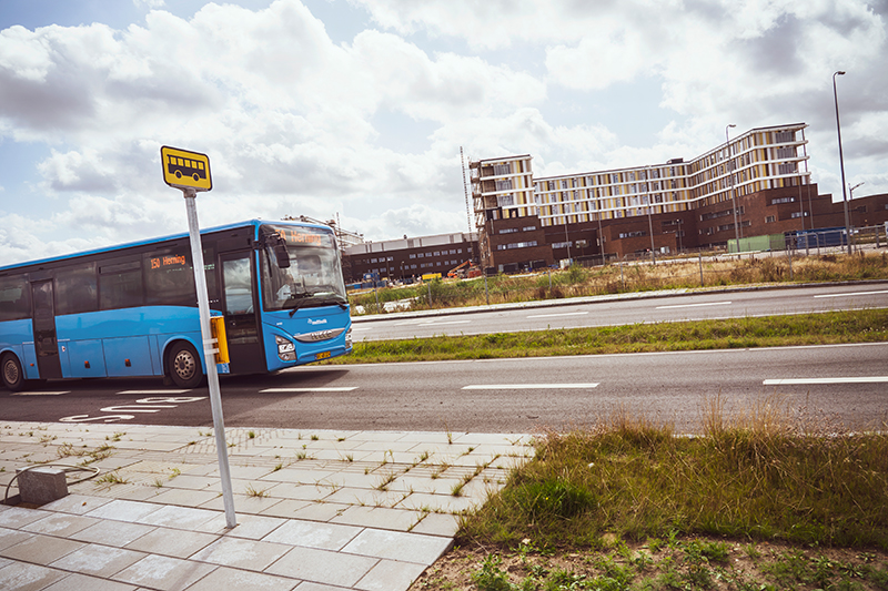 En blå bus fra Midttrafik holder ved stoppested foran Regionshospitalet Gødstrup
