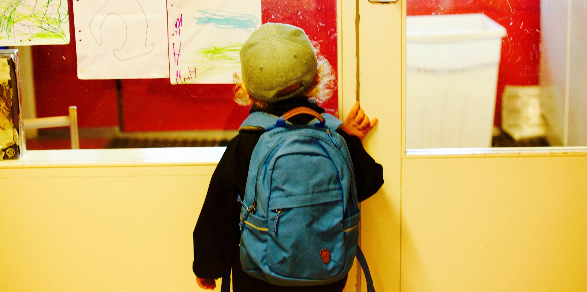 Barn kigger gennem rude til skole
