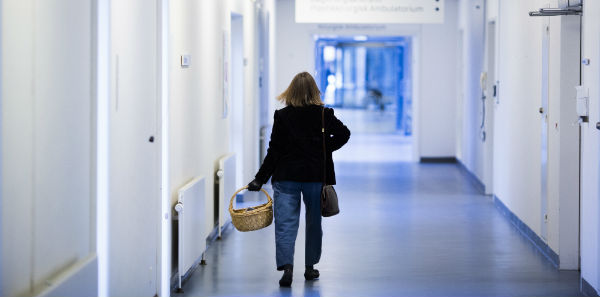 Pårørende går på hospitalsgang med kurv i hånden Guide: Kommunikér bedre i en sygdomsramt familie