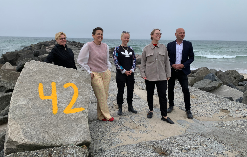 Foto af fire folketingsmedlemmer inkl. miljøministeret og Anders Kühnau ved stendiget ud for forureningen.